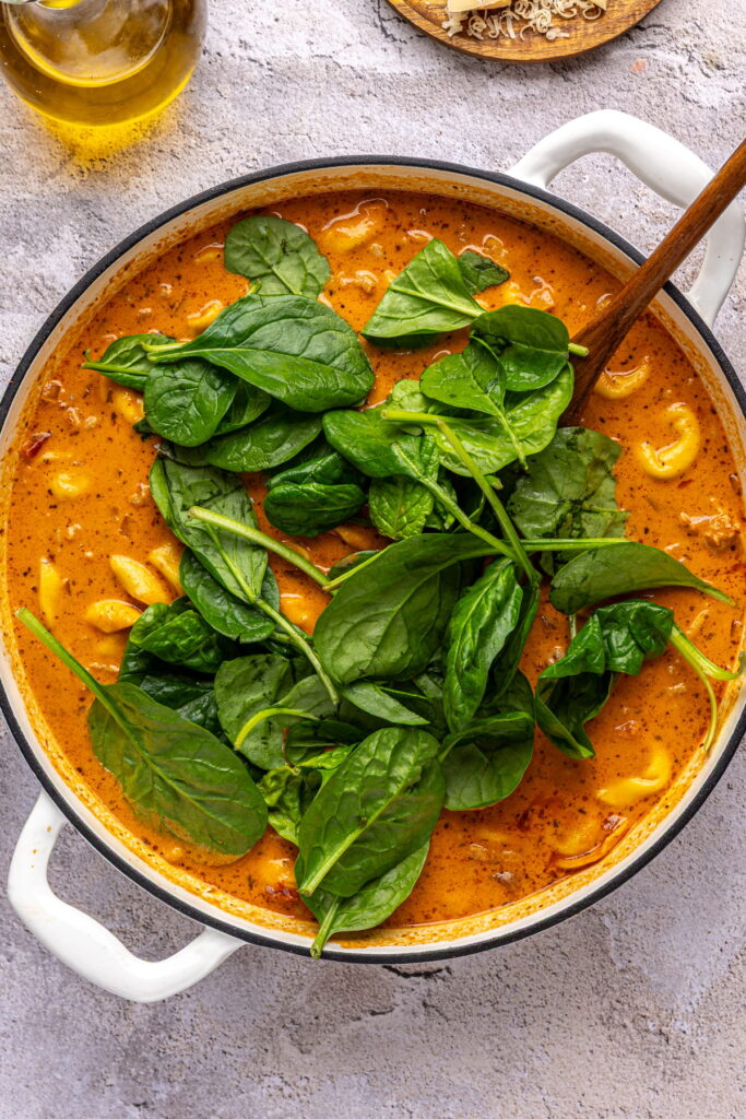 spinach added on top of creamy tomato tortellini soup.