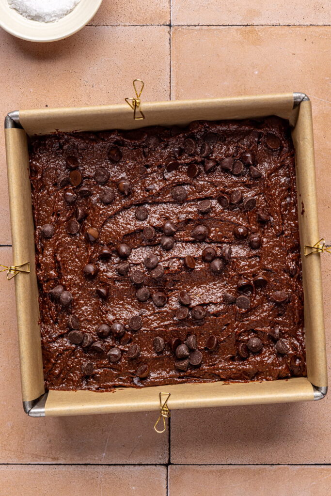 applesauce brownie batter in a prepared pan with chocolate chips on top