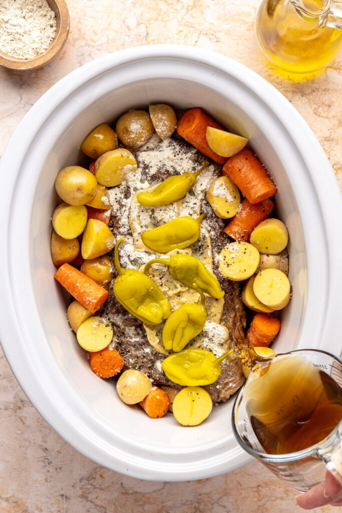 Ingredients for Mississippi pot roast in a slow cooker before being cooked