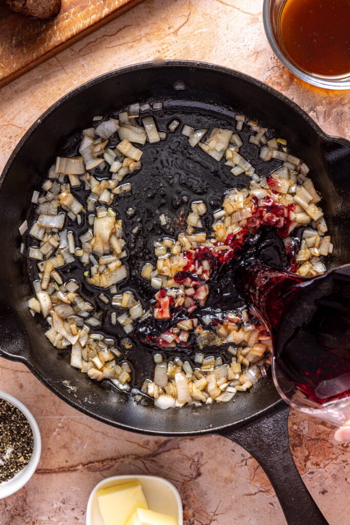 shallots and red wine in a cast iron pan