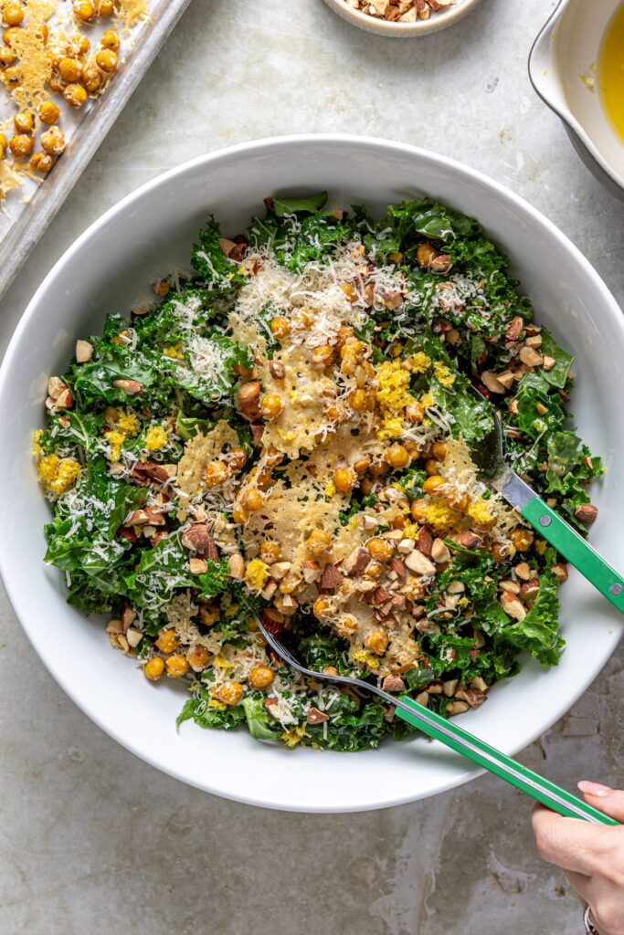 chickpea kale salad being tossed in a bowl