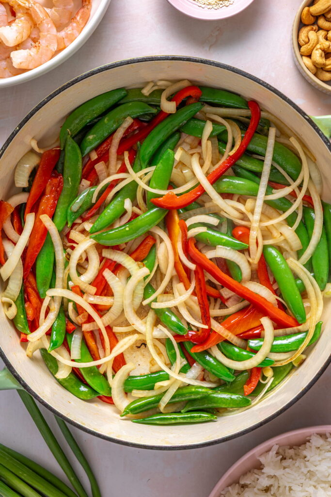 cooking veggies for a shrimp stir fry in a wok