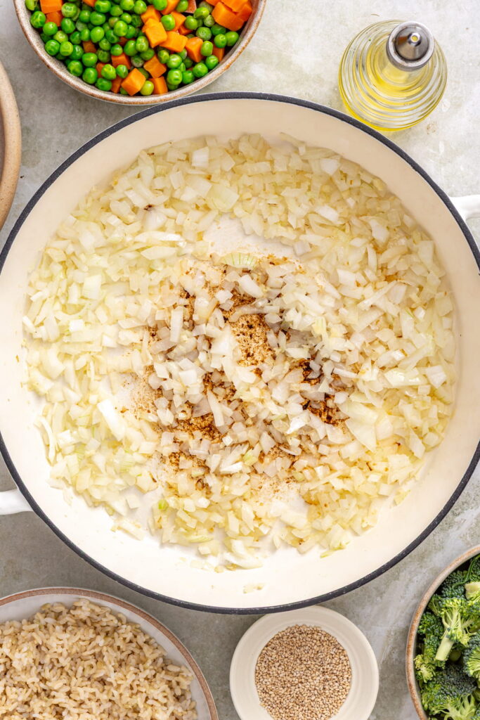 onion, garlic, and ginger sauteing in a skillet