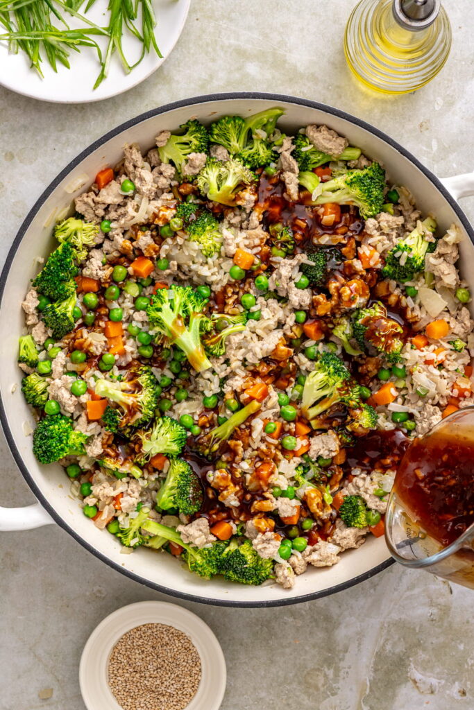 teriyaki sauce being poured on a teriyaki turkey skillet