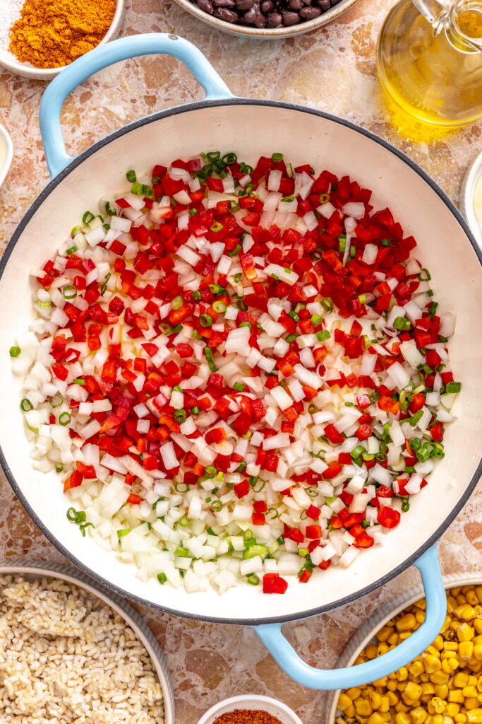sautéing onion, bell pepper, and scallions in a skillet