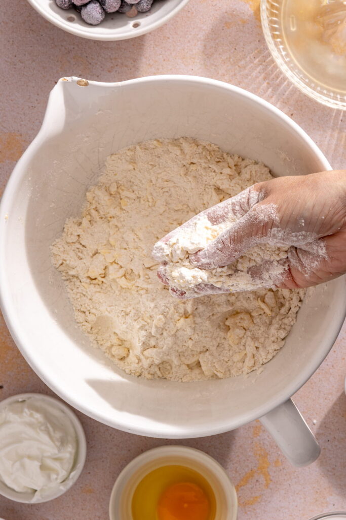 hand working butter into flour mixture for scone dough